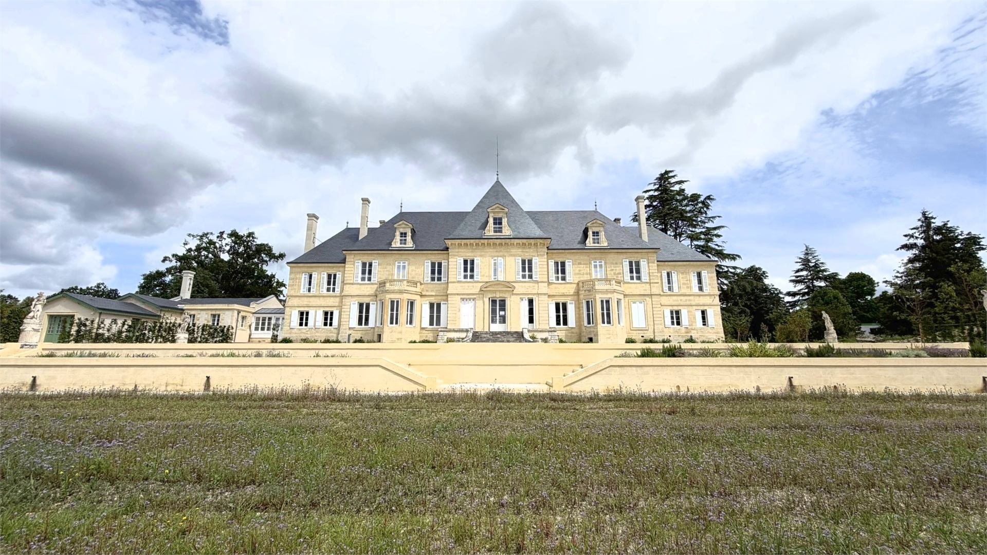 Château restauré en pierre calcaire de Gironde, façade en pierre de taille sous un ciel bleu